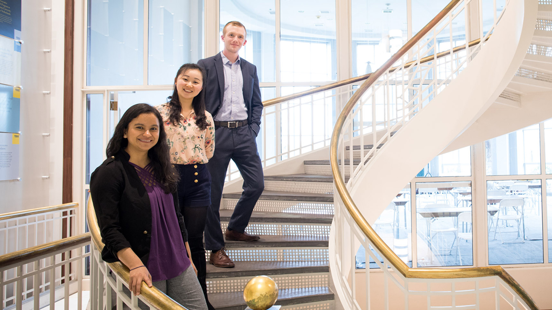 Simon Master's students in the Simon Business School Rotunda stairwell.