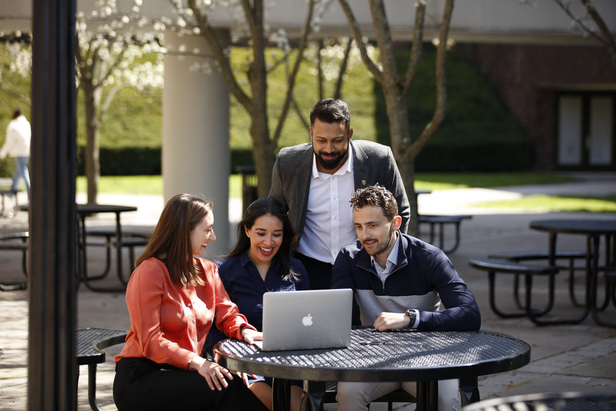 Full-Time MBA students working together outside the University of Rochester Commons.