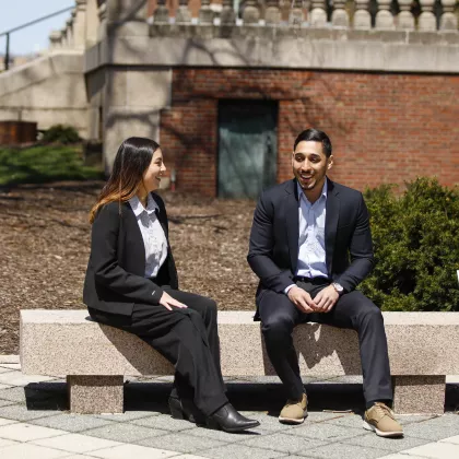 Students chatting on a bench on campus